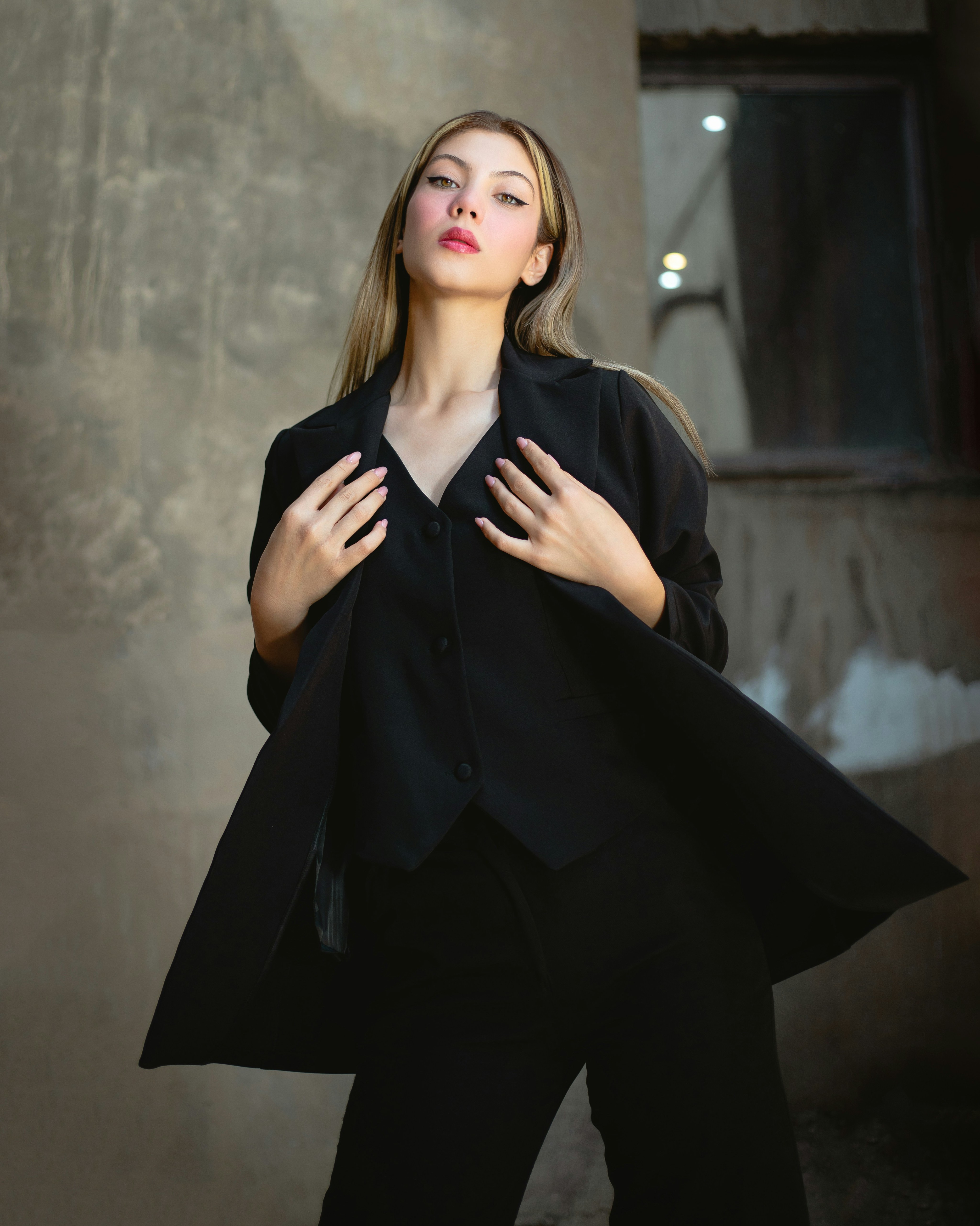 Model in stylish black outfit posing confidently.